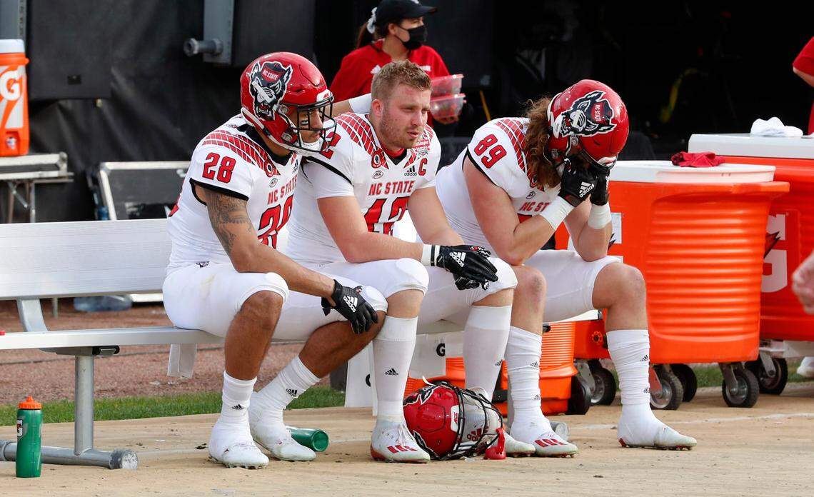 From left, N.C. State’s Dylan Parham (28), Dylan Autenrieth (42) and Thomas Ruocchio (89) sit on the bench after Kentucky’s 23-21 victory over N.C. State in the Gator Bowl at TIAA Bank Field in Jacksonville, Fla., Saturday, January 2, 2021.