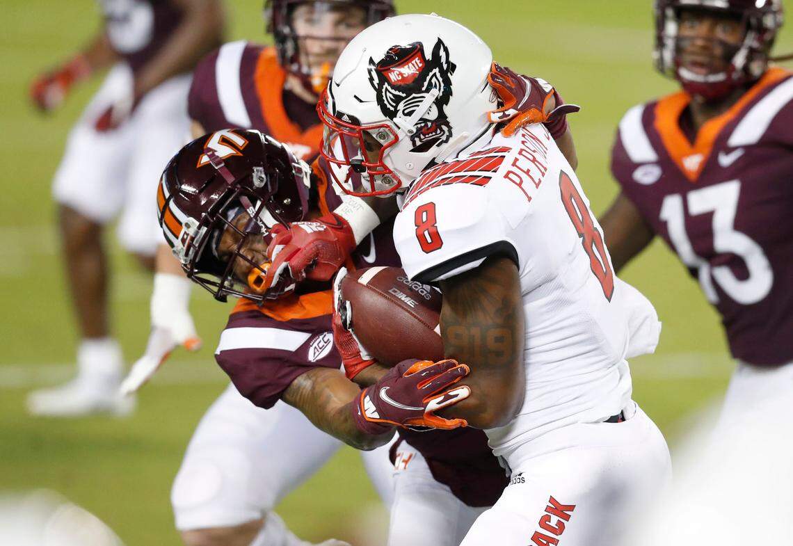 N.C. State running back Ricky Person Jr. (8) battles with Virginia Tech’s Devin Taylor (24) during the first half of N.C. State’s game against Virginia Tech at Lane Stadium in Blacksburg, VA Saturday, Sept. 26, 2020.
