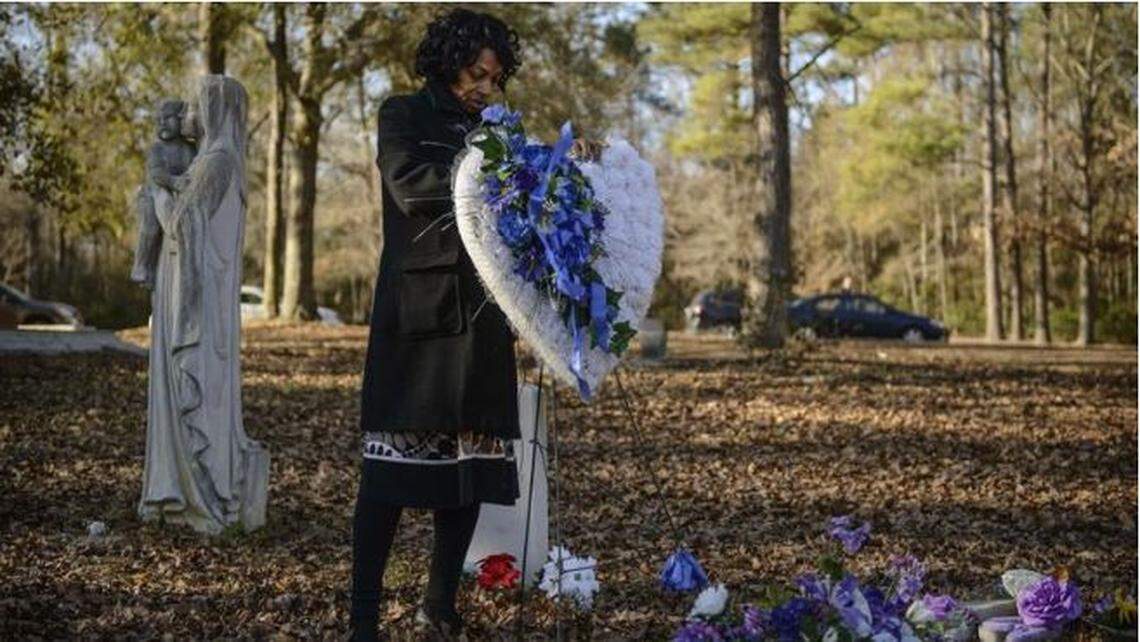 Claudia Lacy, mother of the late Lennon Lacy, places flowers at his grave in a scene from Jacqueline Olive’s “Always in Season.” The film recently won a prize at Sundance Film Festival.