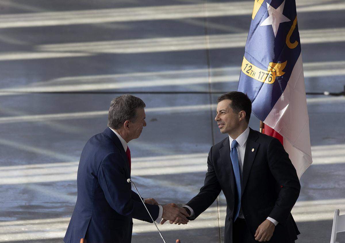 Gov. Roy Cooper shakes hands with U.S. Transportation Secretary Pete Buttigieg during an event at Raleigh Union Station on Monday, Dec. 11, 2023, to celebrate construction of the first leg of a high-speed rail line between the Triangle and Richmond, Va. 