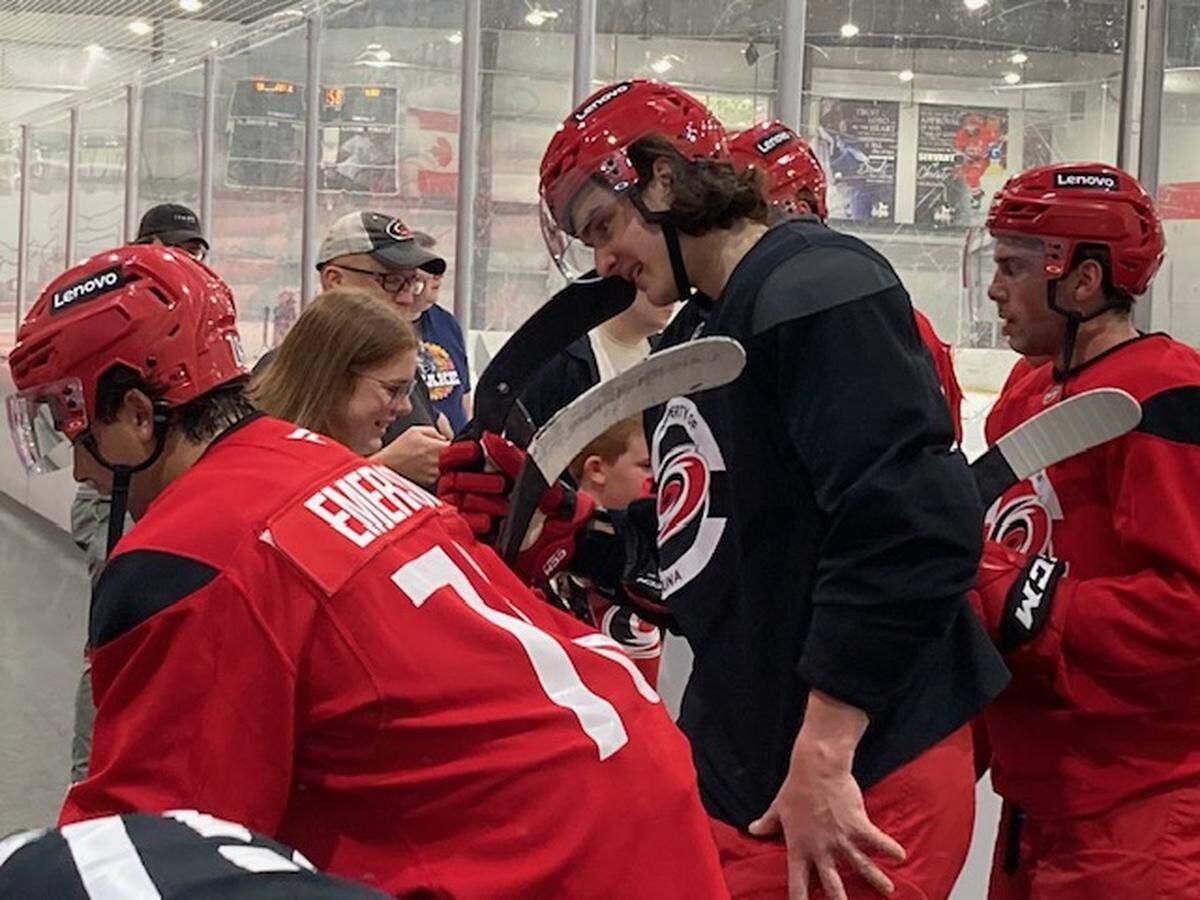 Defenseman Dominik Badinka, in black jersey, signs autographs for fans at Carolina Hurricanes prospects development camp in Morrisville on June 30, 2025. Chip Alexander