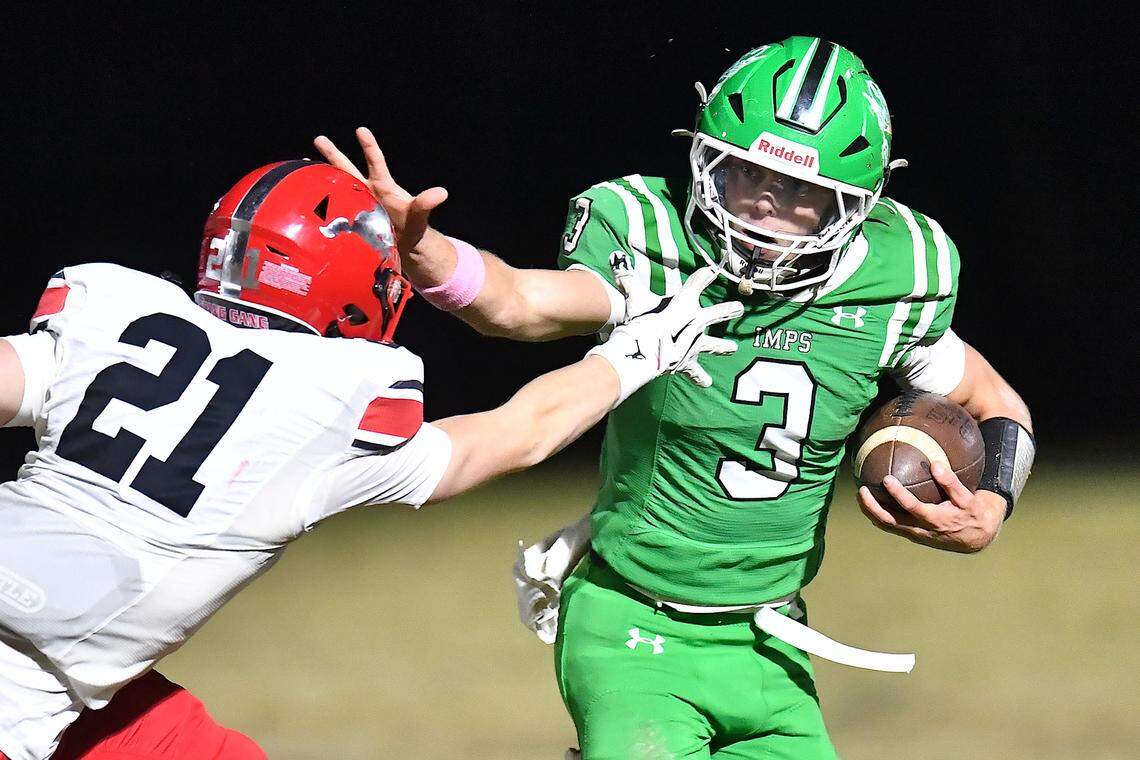 Cary quarterback Nick Grena (3) stiff-arms Middle Creek's Quinn Newman (21) during the first half. The Cary Imps and the Middle Creek Mustangs met in a conference football game in Cary, N.C. on October 24, 2025