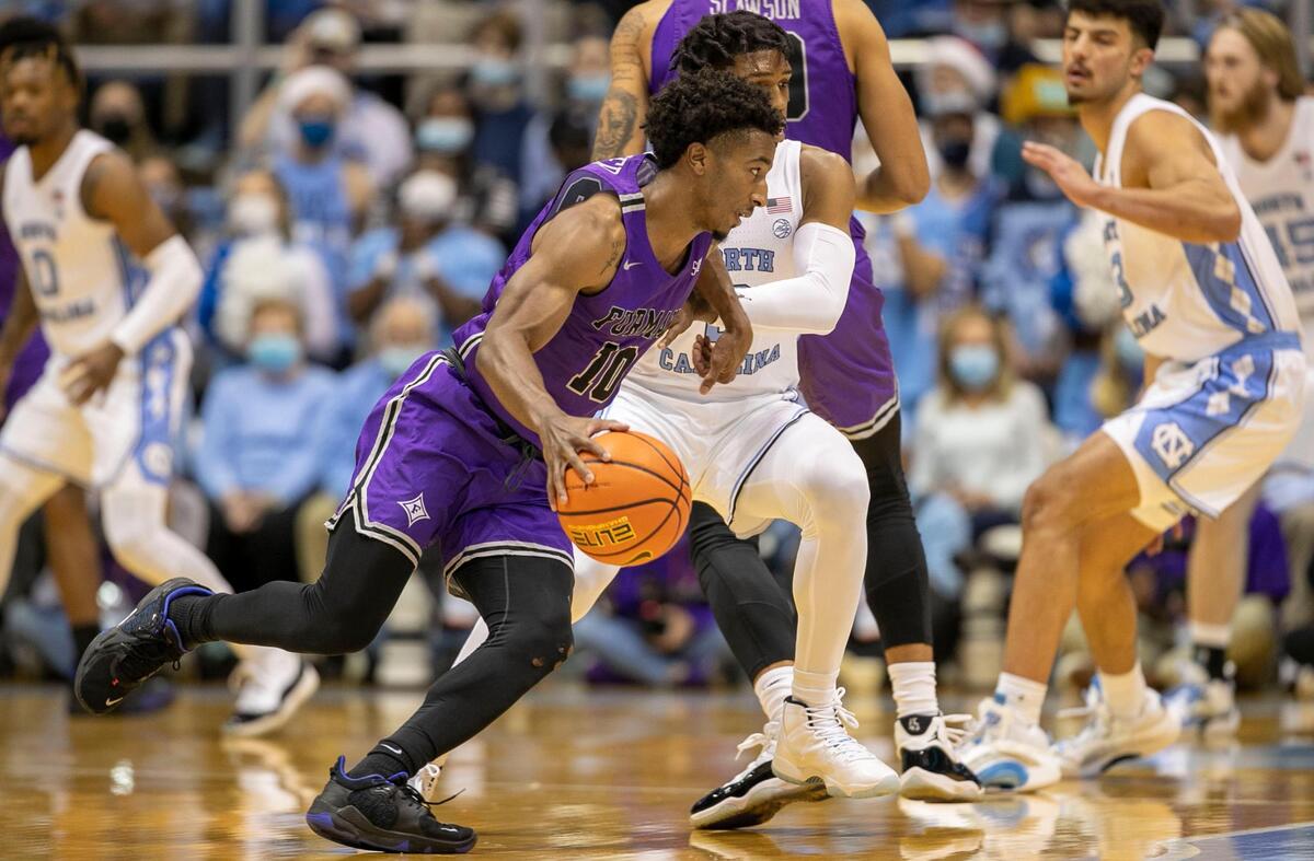 Furman’s Alex Hunter (10), a Leesville High School graduate, runs the offense for the Paladins during the first half against North Carolina on Tuesday, December 14, 2021 at the Smith Center in Chapel Hill, N.C