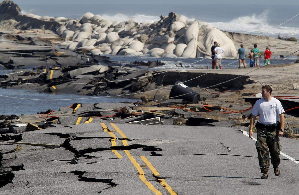 Park Service Ranger Jeff Goad walks and views the destruction to Hwy 12 on the north edge of town following Hurricane Irene in 2011.