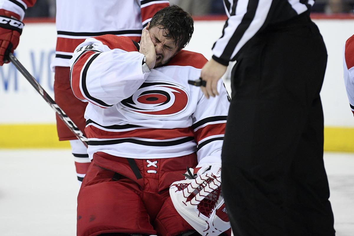 Carolina Hurricanes goaltender Petr Mrazek, of the Czech Republic, reacts as he kneels on the ice after he was hit in the mask by a puck during the second period of Game 2 of an NHL hockey first-round playoff series against the Washington Capitals, Saturday, April 13, 2019, in Washington.