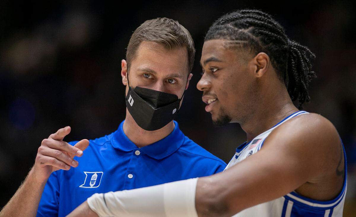 Duke assistant coach Jon Scheyer talks with Trevor Keels (1) during the second half against Elon on Saturday, December 18, 2021 at Cameron Indoor Stadium in Durham, N.C.