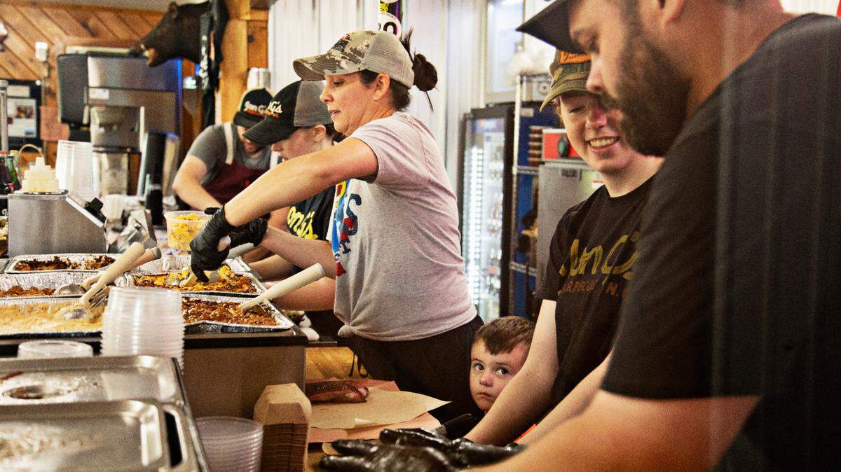 Jon G’s Barbecue is a family affair with Kelly Kirkman, center, son, Gil, and firekeeper Jon Garren Kirkman, far right, on the line Saturday morning, June 25, 2022.