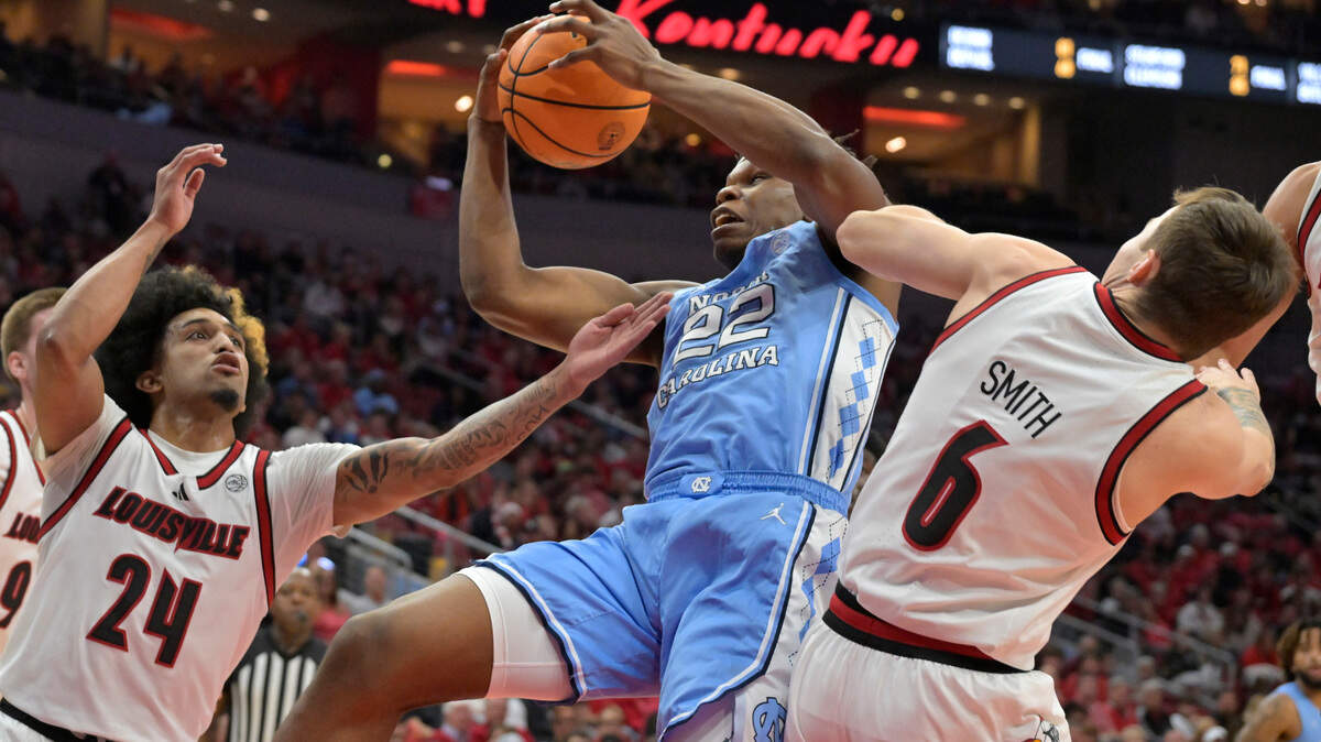 Jan 1, 2025; Louisville, Kentucky, USA; North Carolina Tar Heels forward Ven-Allen Lubin (22) battles Louisville Cardinals guard Chucky Hepburn (24) and guard Reyne Smith (6) for a rebound during the first half at KFC Yum! Center.