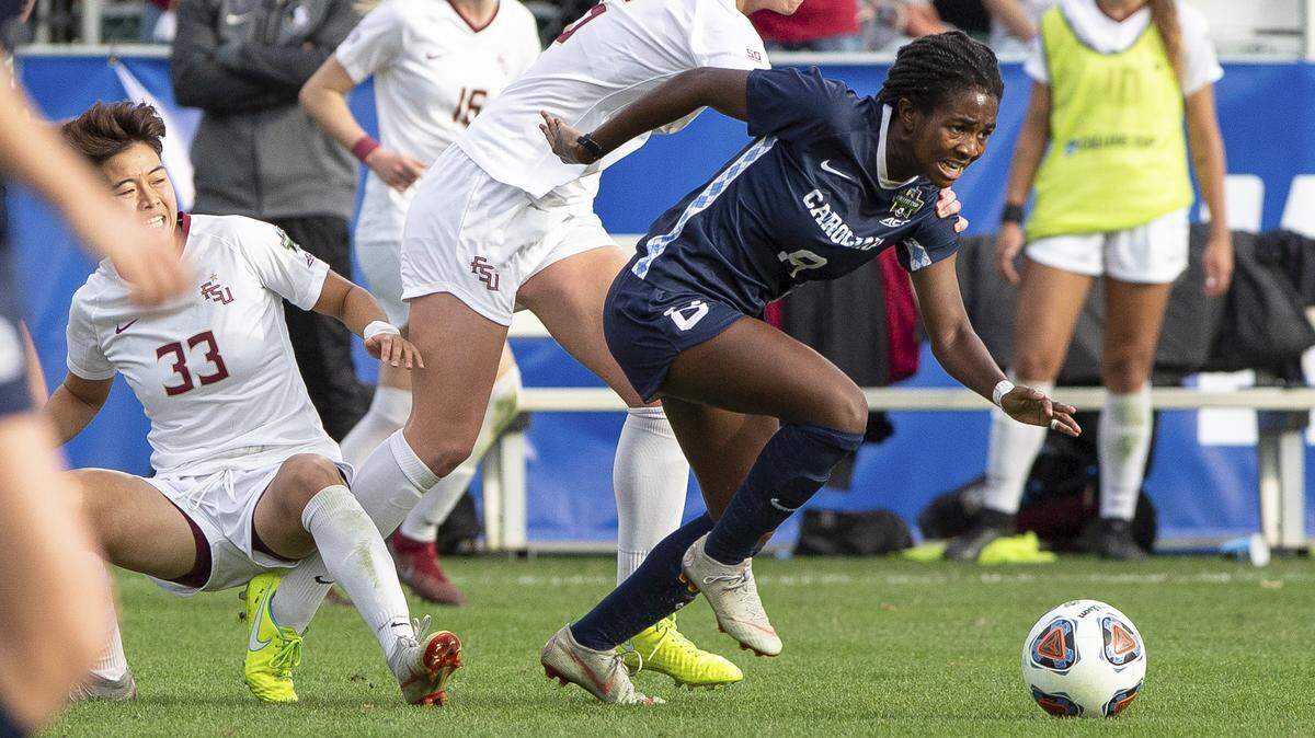 In this 2018 file photo, North Carolina’s Brianna Pinto, right, handles the ball ahead of Florida State’s Anna Patten (5) and Yujie Zhao (33) during the second half of an NCAA women’s soccer championship game in Cary, N.C., Sunday, Dec. 2, 2018.