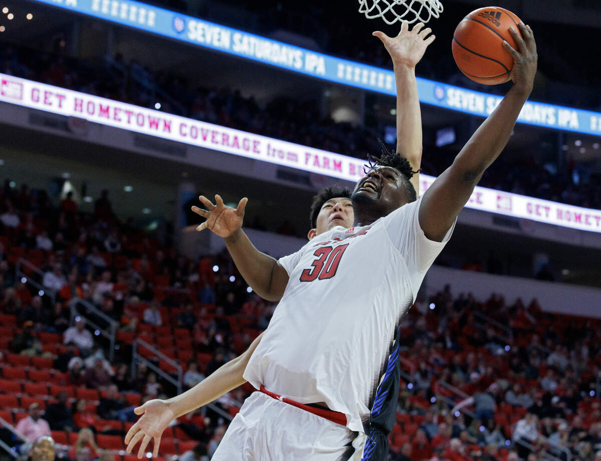 N.C. State’s DJ Burns Jr. drives to the basket past Saint Louis’ Bruce Zhang during the second half of the Wolfpack’s 82-70 win on Wednesday, Dec. 20, 2023, at PNC Arena in Raleigh, N.C.