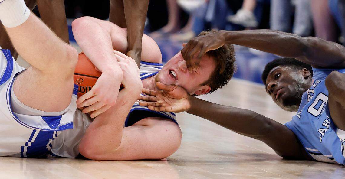 Duke’s Kon Knueppel (7) dives on a loose ball as North Carolina’s Drake Powell (9) tries to take it from him during the first half of Duke’s game against UNC in the semifinals of the 2025 ACC Men’s Basketball Tournament at the Spectrum Center in Charlotte, N.C., Friday, March 14, 2025.