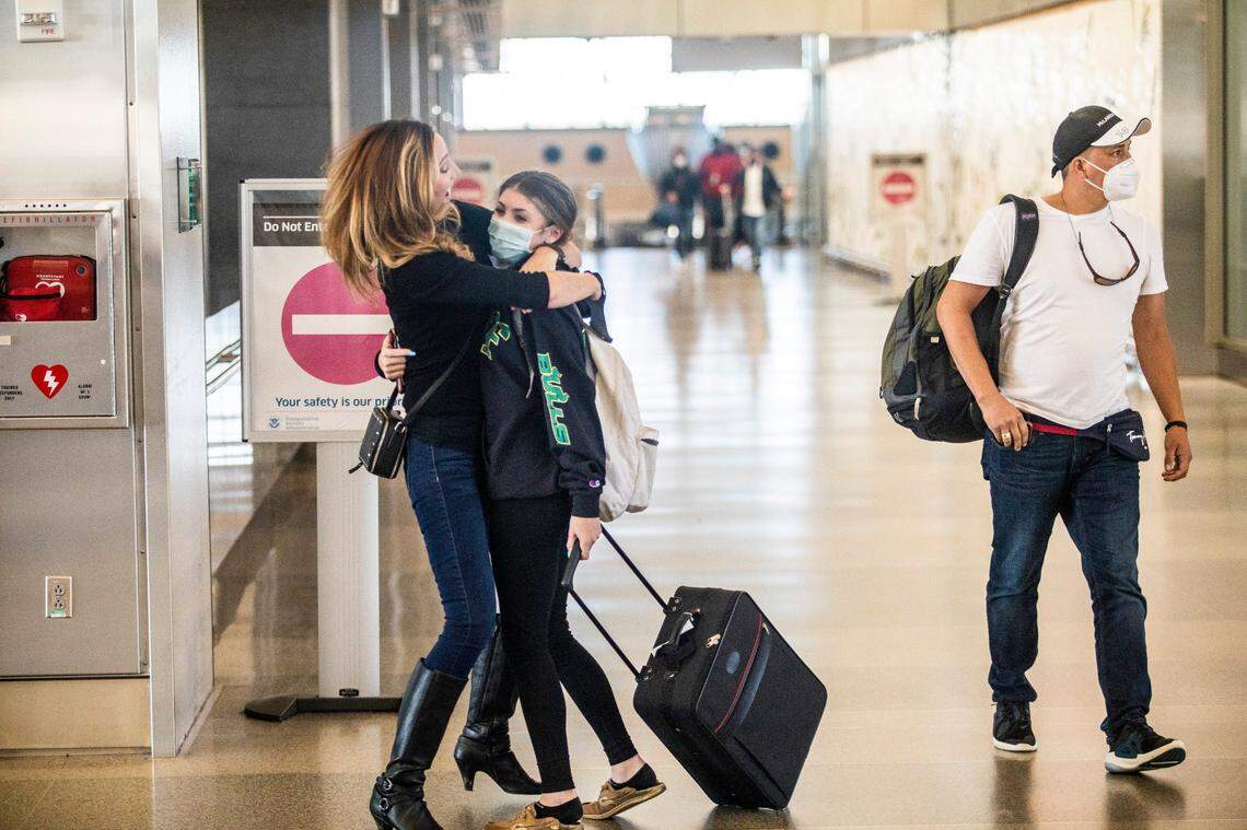 Taryn Zerner, left, hugs her cousin Racheal Law as she arrives in Terminal 2 at Raleigh-Durham International Airport in Morrisville. Airports have seen an increase in travelers as the holidays approach.
