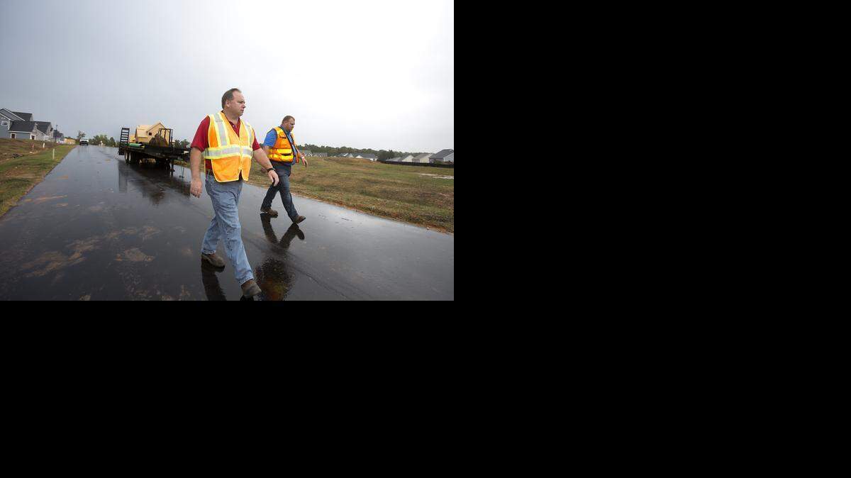 Scott Wheeler, senior assistant district engineer, left, and Jason Dunigan, advanced technician, both with the NCDOT, do one of their site visits to the Avocet subdivision in Holly Springs on Tuesday, October 14, 2014. At minimum, they do five site visits on a job before they take over responsibilities for a road.
