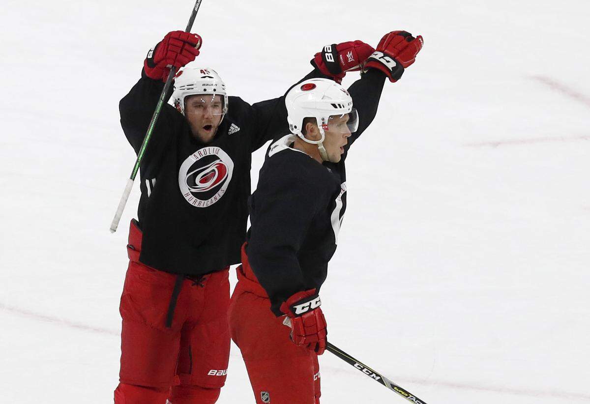 Carolina’s Sami Vatanen (45), left, and Jake Gardiner (51) celebrate a goal by Gardiner during the Carolina Hurricanes’ on-ice workouts at PNC Arena in Raleigh, N.C., Monday, July 13, 2020.