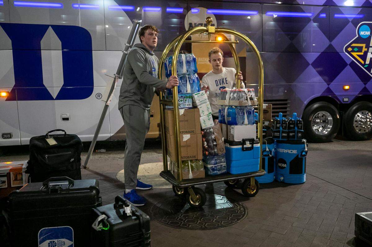 Duke basketball managers unload the team bus at the InterContinental Hotel on Tuesday, March 29, 2022 in New Orleans, La.
