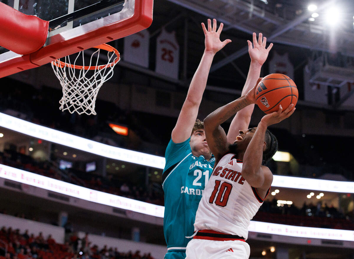 N.C. State’s Marcus Hill drives to the basket past Coastal Carolina’s Noah Amenhauser during the second half of the Wolfpack’s 82-70 win on Wednesday, Nov. 13, 2024, at Lenovo Center in Raleigh, N.C.
