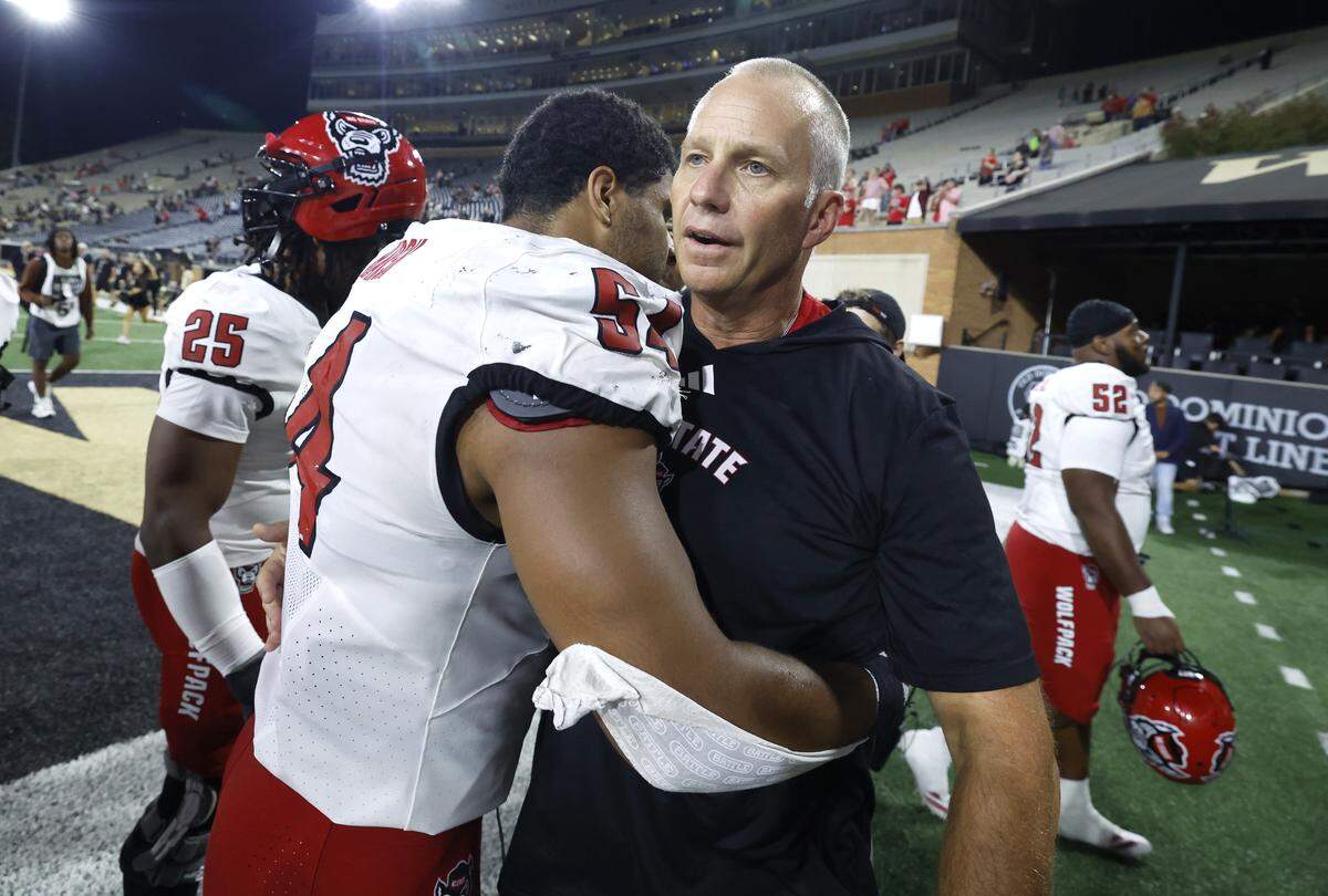 N.C. State head coach Dave Doeren hugs N.C. State defensive end Sabastian Harsh (54) after the Wolfpack’s 34-24 victory over Wake Forest at Allegacy Stadium in Winston-Salem, N.C., Thursday, Sept. 11, 2025.