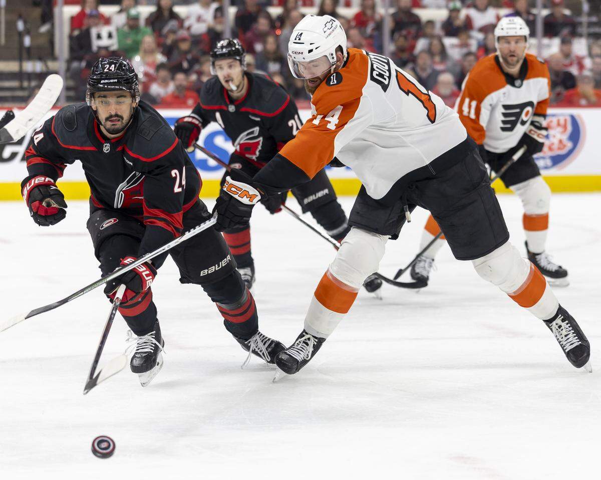Carolina Hurricanes center Seth Jarvis (24) and Philadelphia center Sean Couturier (14) battle to control the puck in the first period of Game 1 on Saturday, May 2, 2026, during the second round of the Stanley Cup Playoffs at Lenovo Center in Raleigh, N.C.