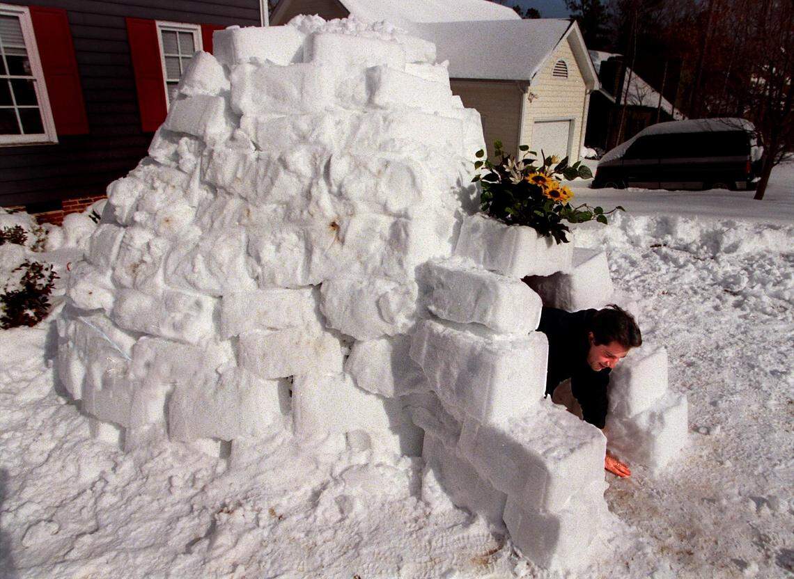 Mike Beaman climbs out of the igloo he built from blocks made by packing snow in the a recycling container in the days following a storm that dumped two feet of snow on the Triangle in one January night in 2000.