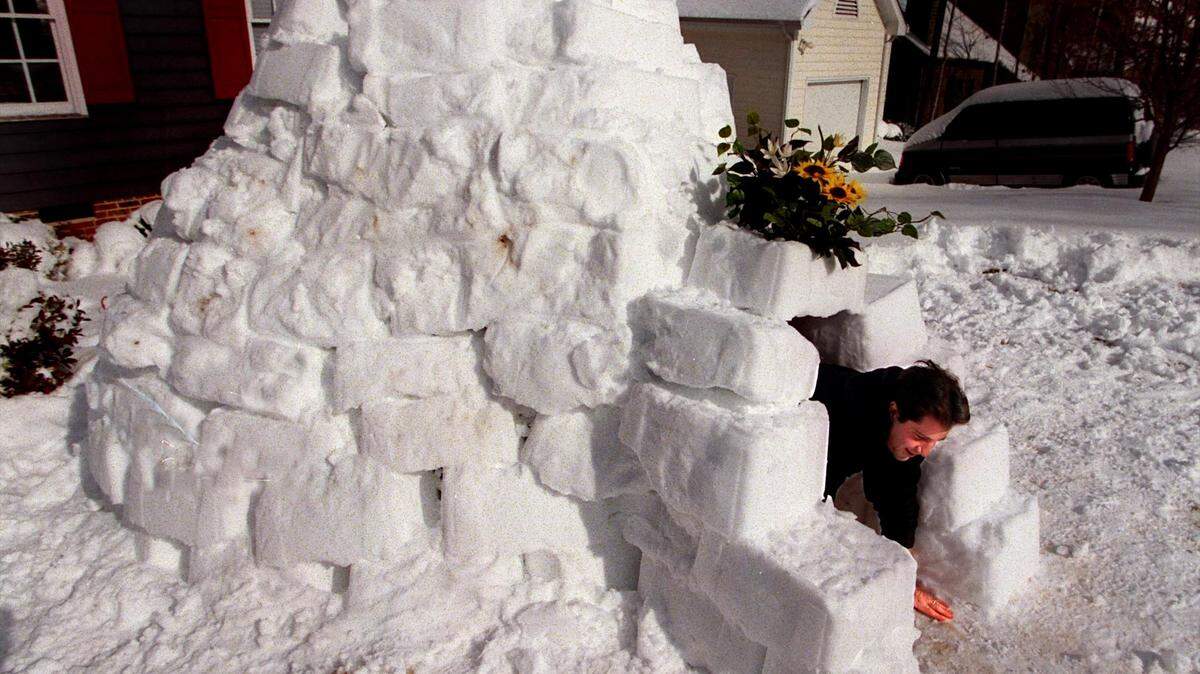 Mike Beaman climbs out of the igloo he built from blocks made by packing snow in the a recycling container in the days following a storm that dumped two feet of snow on the Triangle in one January night in 2000.