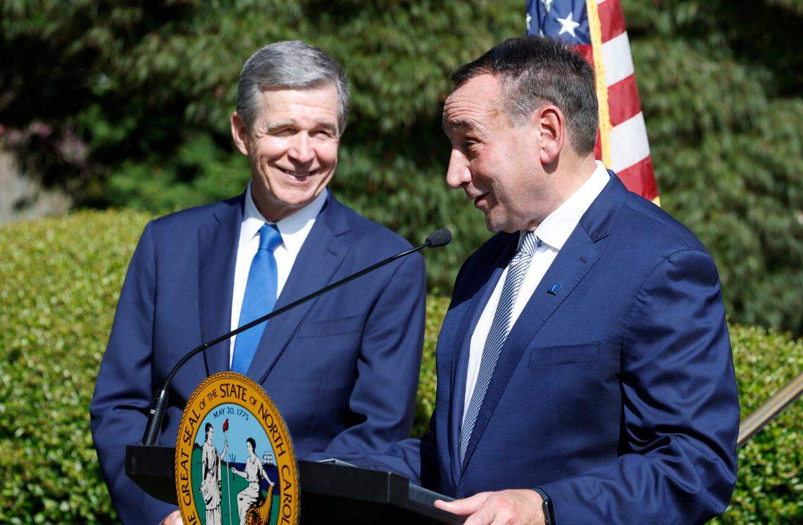 N.C. Gov. Roy Cooper laughs with former Duke men’s basketball head coach Mike Krzyzewski as he speaks after receiving The Order of the Long Leaf Pine award during a ceremony at the Executive Mansion in Raleigh, N.C., Thursday, Sept. 1, 2022. The Order of the Long Leaf Pine award is the state’s highest civlian honor.