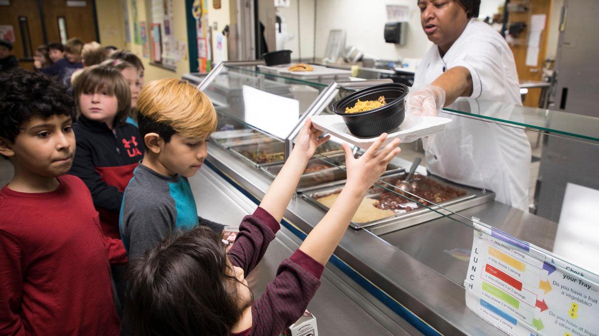 Students line up for lunch at George Watts Elementary School in Durham in this 2019 file photo. A new plan to provide free meals to all students would make Durham the largest school district in North Carolina to give free meals to everyone, regardless of family income.