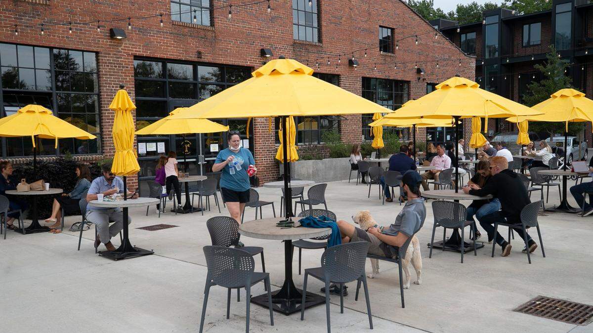 The outdoor dining area at the Transfer Co. Food Hall on E. Davie Street on Friday, October 9, 2020 in Raleigh, N.C. Cement tables are spaced out for social distancing, preventing patrons from moving tables together. 
