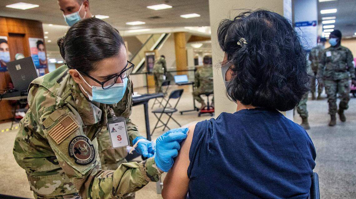 Kimberly Newman, a U.S. Air Force medic, prepares to administer a vaccination to Jeong Hwa Song during a mass vaccination clinic Wednesday, March 10, 2021 at Four Season Town Center in Greensboro. The clinic expects to vaccinate 3000 people per day over eight weeks.