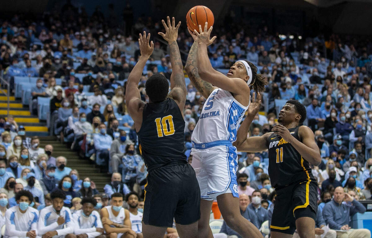North Carolina’s Armando Bacot (5) drives to the basket against Appalachian State’s Michael Eads Jr. (10) and Donovan Gregory (11) during the second half on Tuesday, December 21, 2021 at the Smith Center in Chapel Hill, N.C. Bacot lead the Tar Heels with 16 points in their 70-50 victory.