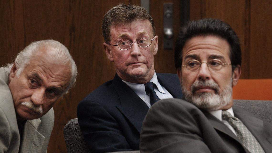 Defense investigator Ron Guerette (left), Michael Peterson (center) and attorney David Rudolf look back at Kathleen Peterson's family prior to the start of court proceedings in June 2003, while Peterson was on trial for the murder of his wife Kathleen Peterson.