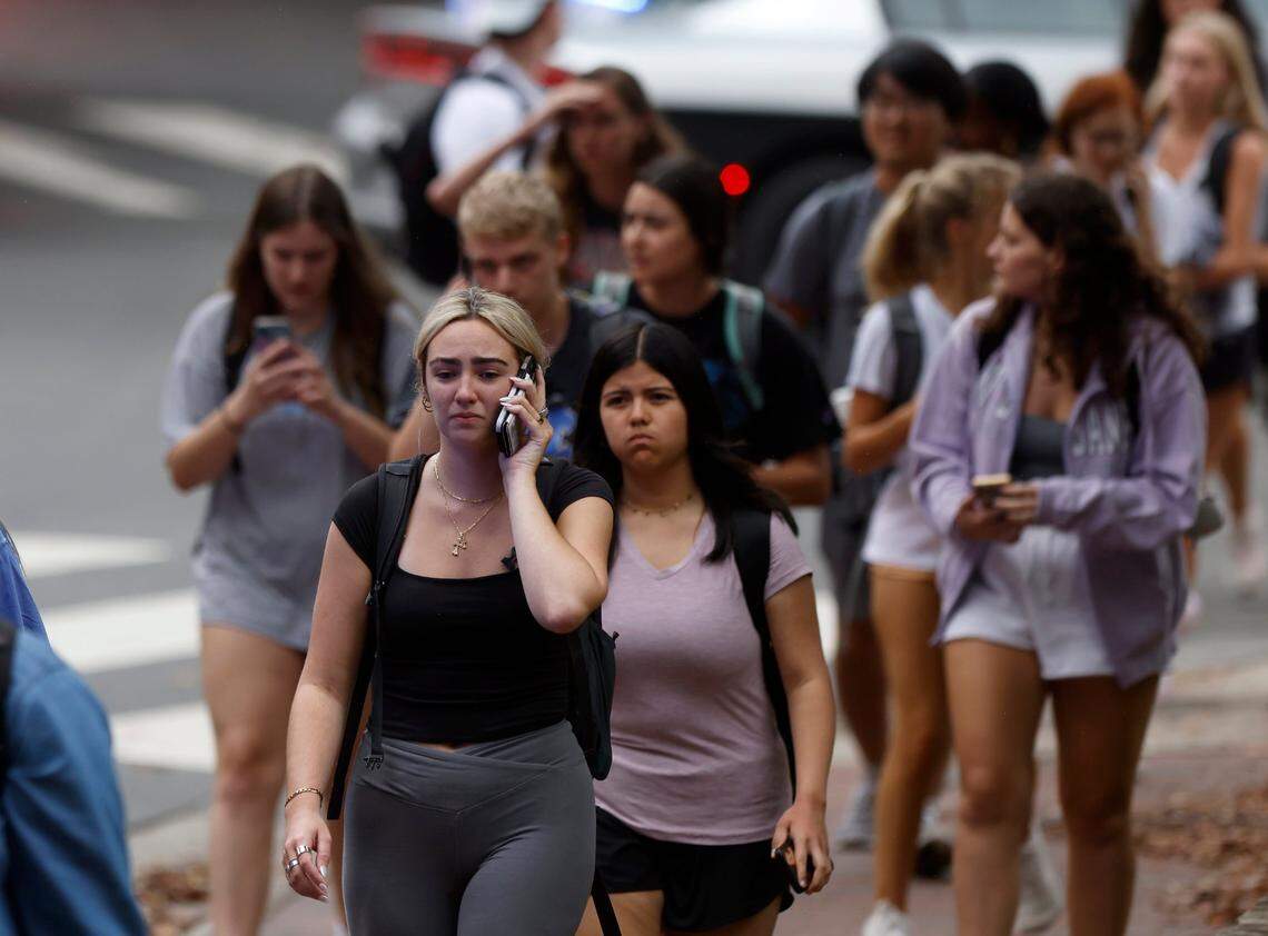 People walk along South Road as law enforcement responds to an “active assailant situation” on the campus of UNC-Chapel Hill on Monday, Aug. 28, 2023.