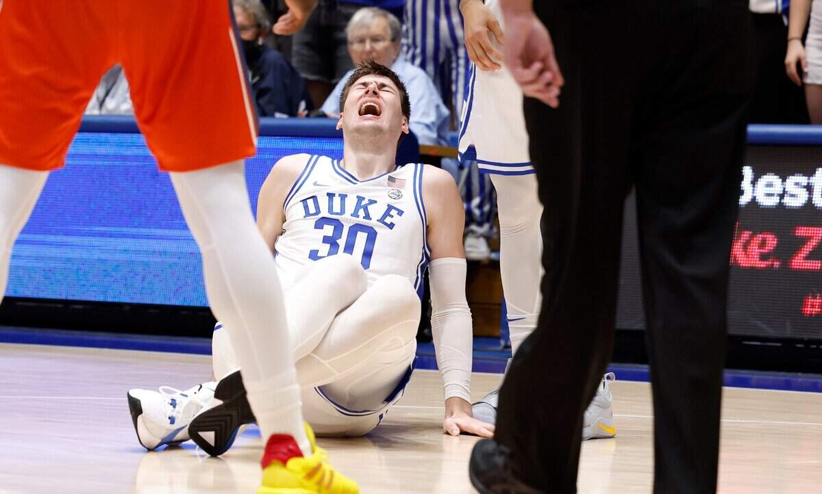 Duke’s Kyle Filipowski winces in pain after he was injured during the first half of Duke’s game against Bucknell at Cameron Indoor Stadium in Durham, N.C., Friday, Nov. 17, 2023. Filipowski was helped off the floor.