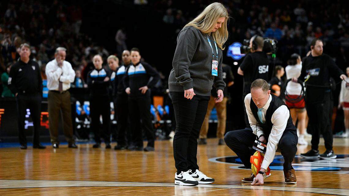 Mar 31, 2024; Portland, OR, USA; NCAA officials measure the three point line while coaches from the Texas Longhorns and NC State Wolfpack watch with referees in the finals of the Portland Regional of the NCAA Tournament at the Moda Center.