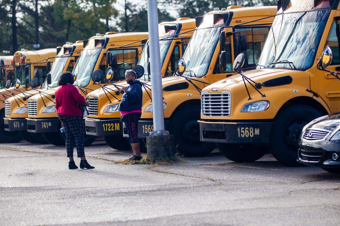 Wake County school bus drivers return to a parking area on Capital Blvd. in Raleigh after completing morning routes Friday, Oct. 29, 2021.