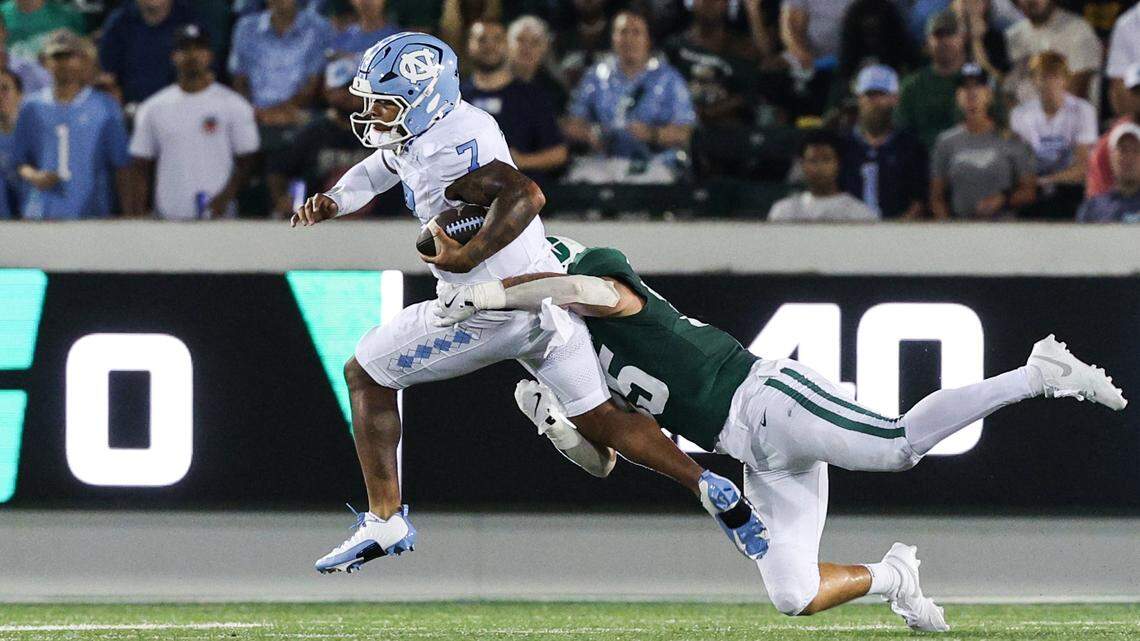 Charlotte linebacker Shay Taylor, right, hangs onto Chapel Hill quarterback Gio Lopez as he runs the ball during the game at Jerry Richardson Stadium in Charlotte on Saturday, September 6, 2025.
