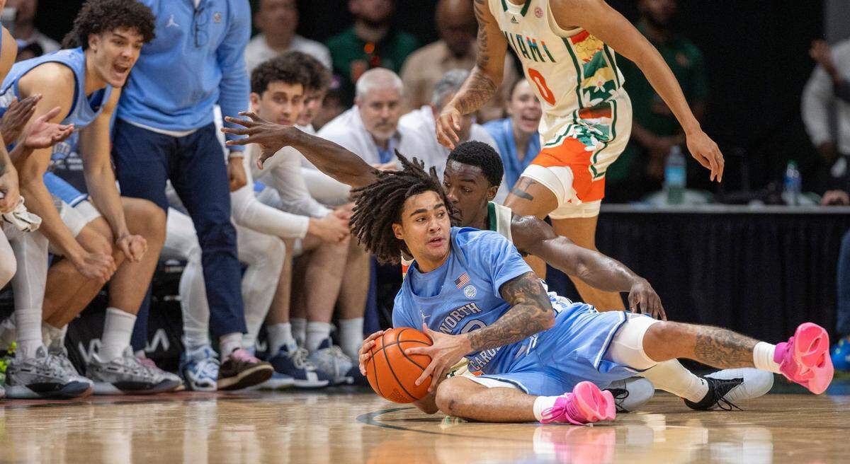 North Carolina’s Elliot Cadeau (2) recovers a turnover by Miami’s Paul Djobel (10) in the first half on Saturday, February 10, 2024 at the Watsco Center in Coral Gables, Florida.