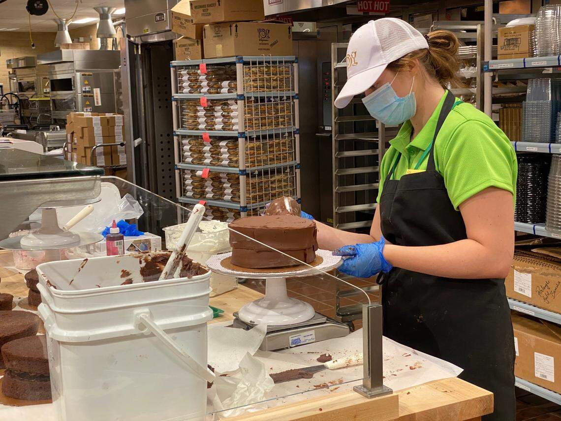 Ania Daisley ices a cake in the West Cary Wegmans bakery on July 27, 2020. The grocery store opens its newest location on Davis Drive on July 29, 2020.
