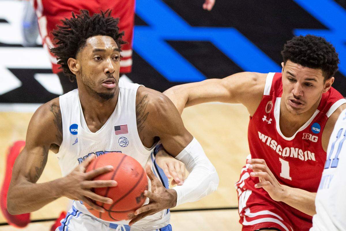 North Carolina’s Leaky Black, left, drives in against Wisconsin’s Jonathan Davis (1) during the first half of a first-round game in the NCAA men’s college basketball tournament, Friday, March 19, 2021, at Mackey Arena in West Lafayette, Ind. 
