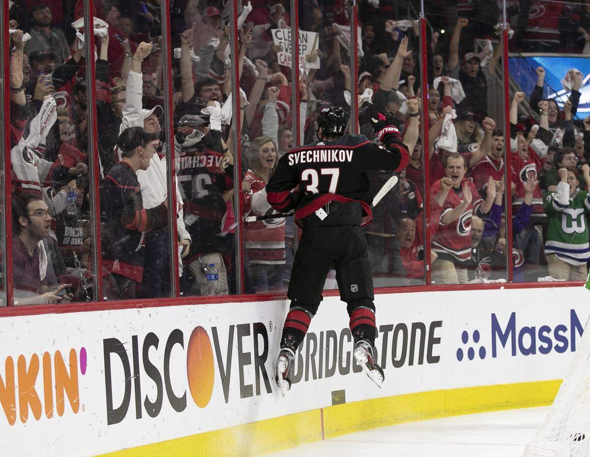 Carolina Hurricanes’s Andrei Svechnikov (37) crashes into the boards to celebrate after scoring on New York Islanders goalie Thomas Greiss (1) during the third period in Game 4 of their Stanley Cup series on Friday, May 3, 2019 at PNC Arena in Raleigh, N.C. The Canes rolled to a 5-2 victory clinching the series 4-0.
