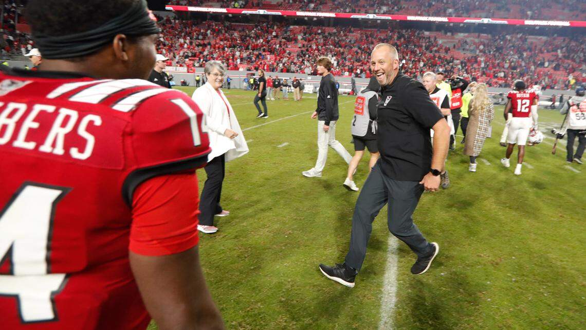 N.C. State head coach Dave Doeren runs to celebrate with quarterback Jack Chambers (14) after N.C. State’s 19-17 victory over Florida State at Carter-Finley Stadium in Raleigh, N.C., Saturday, Oct. 8, 2022.