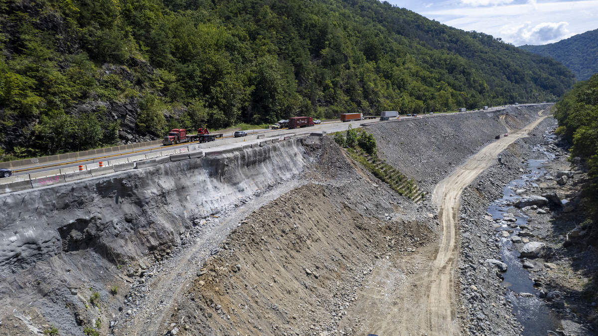 Drivers passing on Interstate 40 get only fleeting glimpses of the construction work along the Pigeon River. Contractors have built a causeway along the river that will allow them  rebuild and shore up the eastbound lanes, which were undermined by the flooding river.