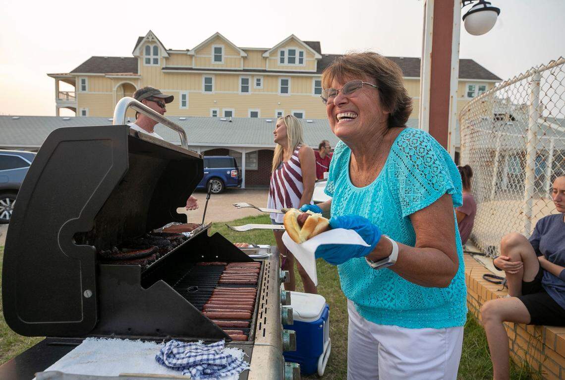 Dale Wescott, the owner of The Cavalier By The Sea motel serves hot dogs to her guests on Wednesday, July 21, 2021 in Kill Devil Hills, N.C. Built by Dale’s parents, Roy and Dot Wescott along NC 12, it opened on Memorial Day in 1950. Many generations of families return each season to enjoy the simple family friendly accommodations on the ocean.