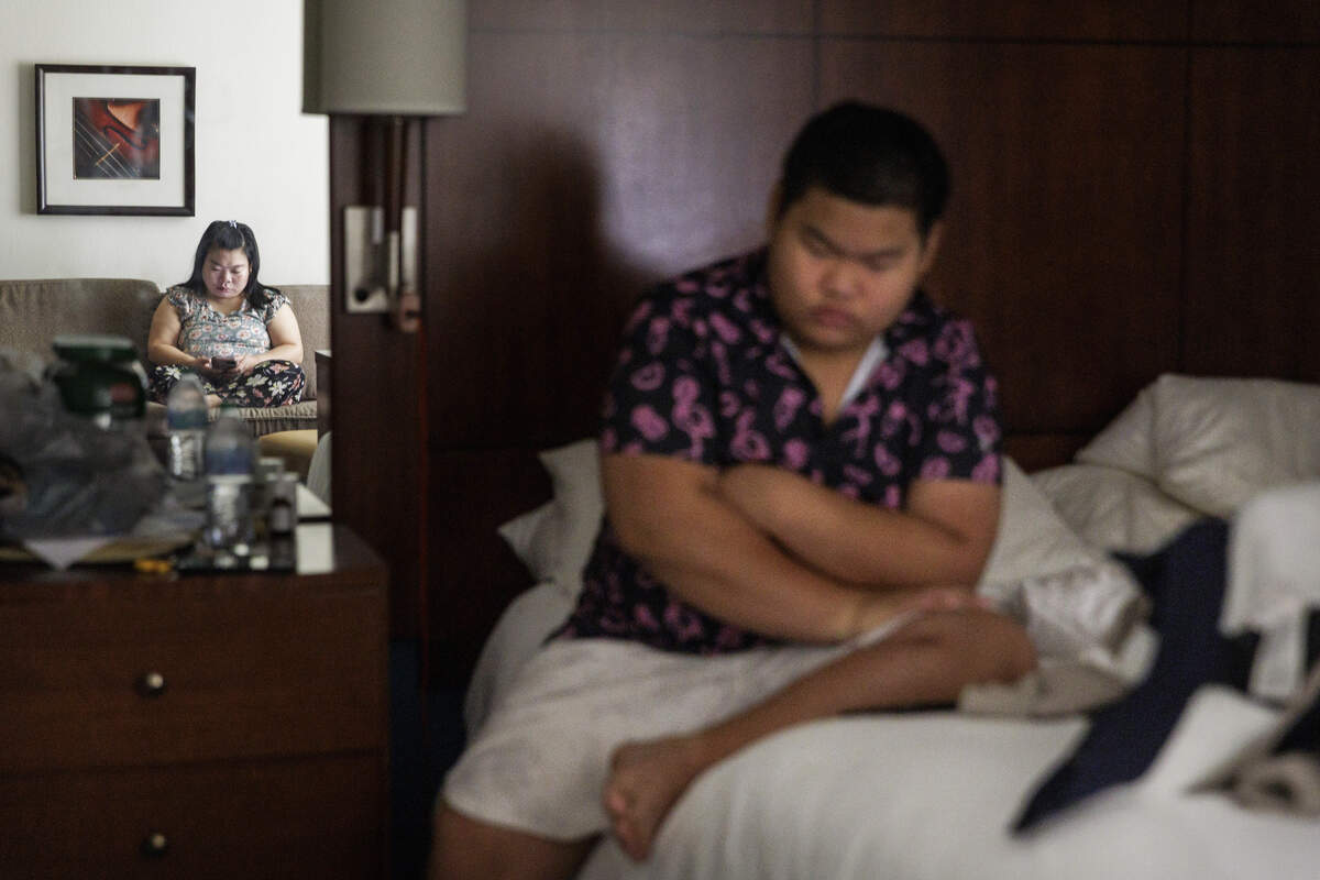 Mu La Pur (left) sits on the sofa while her son Kyawwin Hling sits on the bed while inside the hotel room the family current lives at on Tuesday, June 30, 2026, in Chapel Hill, North Carolina.