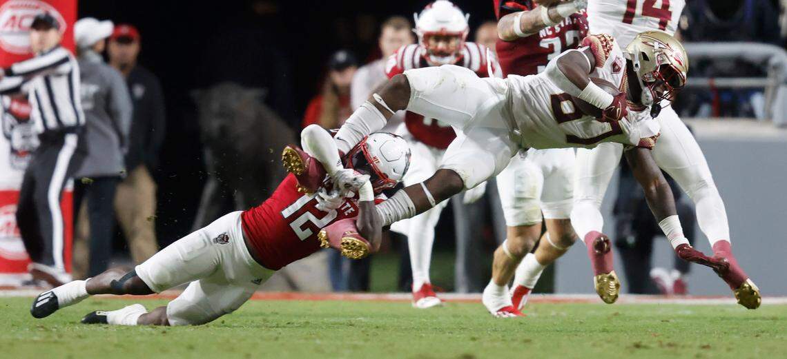 N.C. State defensive back Devan Boykin (12) tackles Florida State tight end Camren McDonald (87) during the first half of N.C. State’s game against Florida State at Carter-Finley Stadium in Raleigh, N.C., Saturday, Oct. 8, 2022.