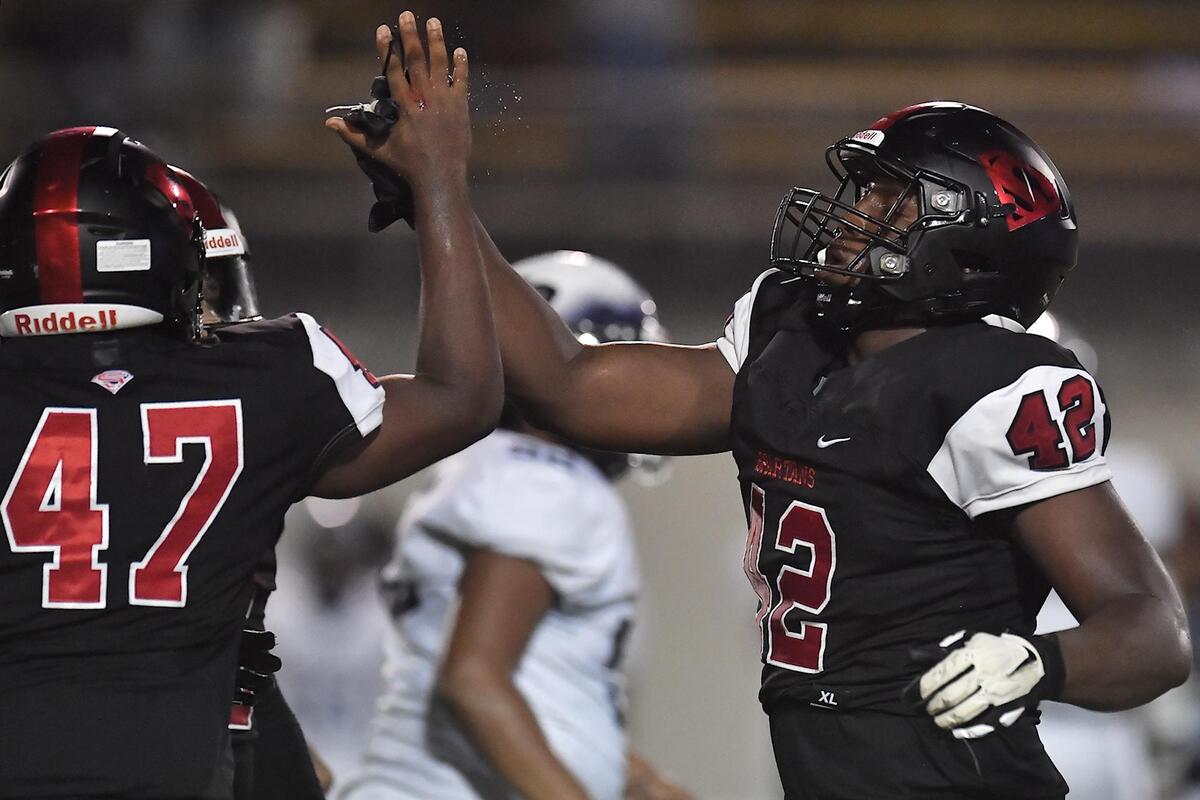 Soutern Durham’s Isaiah Campbell (42) congratulates Elisha Roberts (57) after a play during the first half. The Southern Durham Spartans and the Hillside Hornets met in a non-conference football game at Durham County Stadium on August 25, 2023.