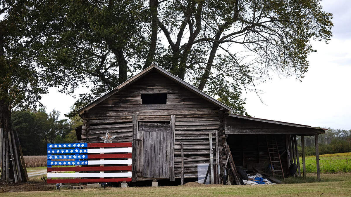 A flag painted on a wooden pallet along a backroad in rural North Carolina.