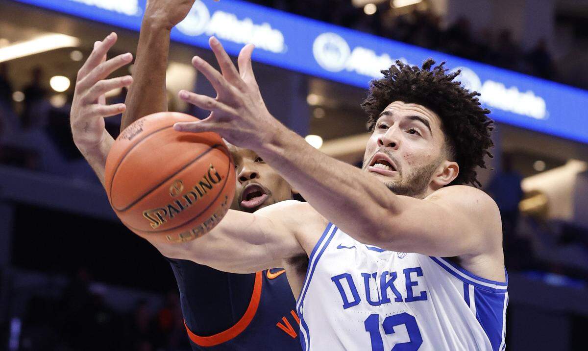 Duke’s Cameron Boozer (12) pulls in the rebound from Virginia's Ugonna Onyenso (33) during the first half of Duke’s game against Virginia in the finals of the 2026 ACC Men’s Basketball Tournament at the Spectrum Center in Charlotte, N.C., Saturday, March 14, 2026.
