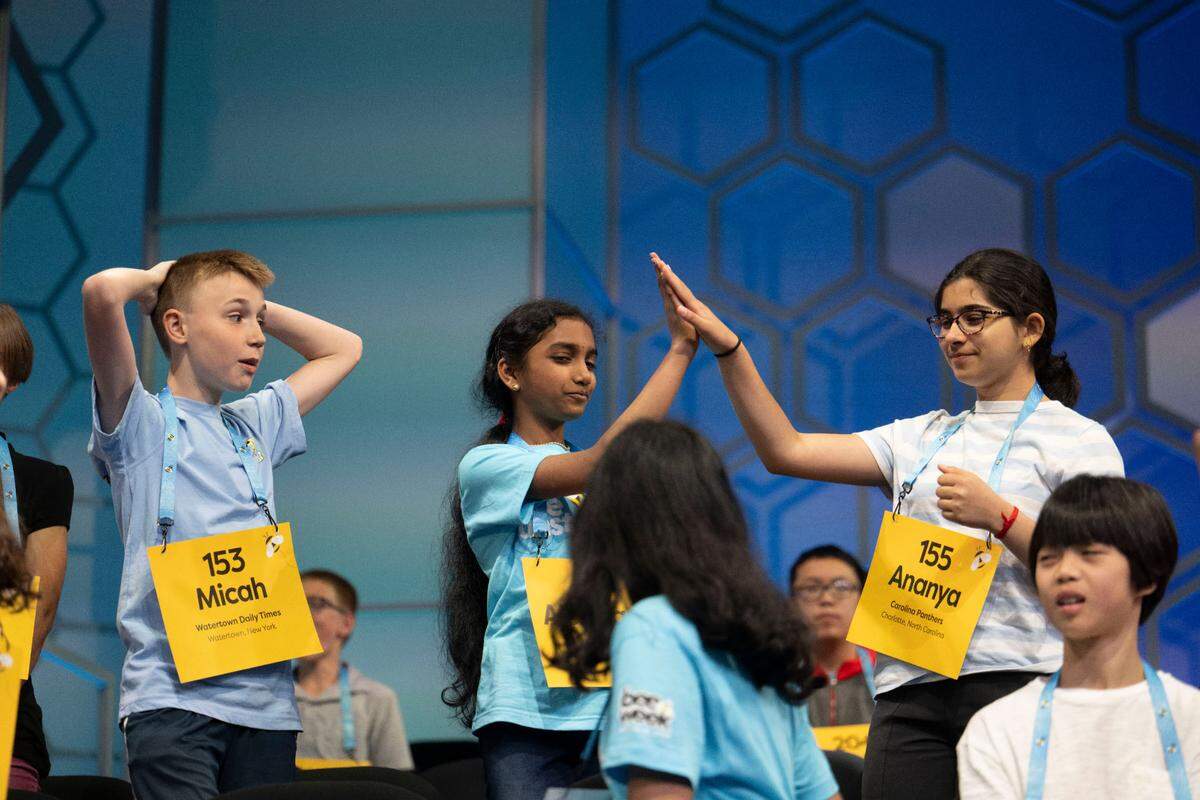 Ananya Rao Prassanna (right) gives a high-five to Aishwarya Kallakuri in the Quarterfinals of the 2024 Scripps National Spelling Bee in National Harbor, MD, on May 29, 2024. Prassanna, a student at Davis Drive Middle School in Cary, N.C., earned a spot in the finals.