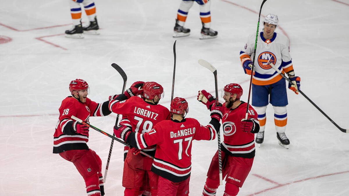 Carolina Hurricanes’ Jordan Martinook (48) is surrounded by teammates Ian Cole (28), Steven Lorentz (78), Tony DeAngelo (77) after scoring in the second period on Thursday, October 14, 2021 at PNC Arena in Raleigh, N.C.