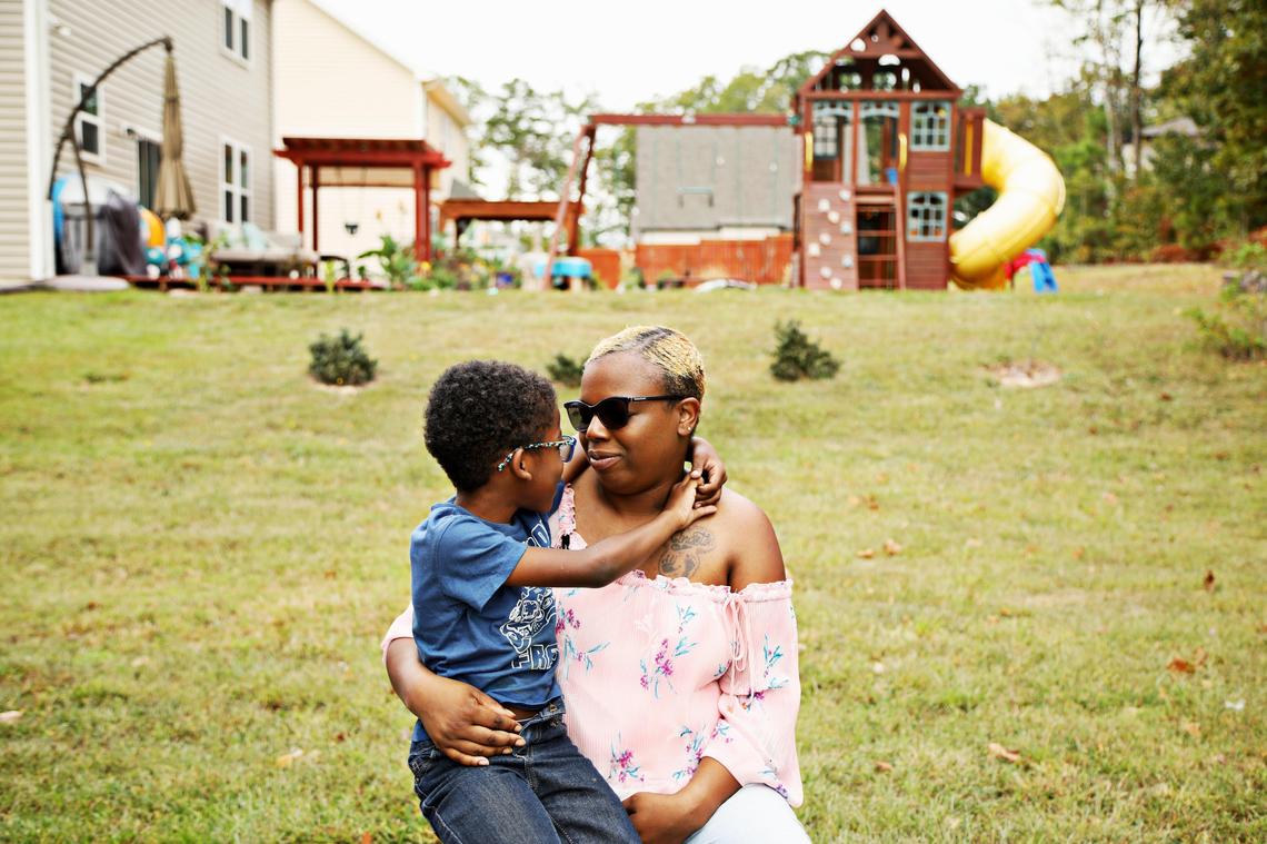 Laura Miles holds her oldest living son, Dasan, 7, in the family’s Durham backyard on Oct. 5, 2019.